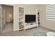 Bright living room featuring a TV, built-in shelves, and an open doorway to another room at 3504 Golden Wheat Ln, Plant City, FL 33565