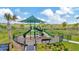 Fully fenced playground with a canopy and a variety of climbing structures and slides at 3504 Golden Wheat Ln, Plant City, FL 33565