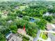 Aerial view of the home, highlighting the pool, mature trees, landscaping, and neighborhood at 4215 Water Oaks Ln, Tampa, FL 33618