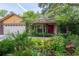 Charming home with mature landscaping, brick accents, and a vibrant red front door at 4215 Water Oaks Ln, Tampa, FL 33618