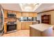 Bright kitchen featuring stainless appliances, an island, tile floors, and light wood cabinets at 4215 Water Oaks Ln, Tampa, FL 33618