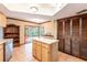 Bright kitchen with an island, wood cabinets, pantry, and an easy access to screened outdoor dining at 4215 Water Oaks Ln, Tampa, FL 33618