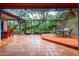 A screened patio featuring tiled floors, multiple seating areas, and view of the garden at 4215 Water Oaks Ln, Tampa, FL 33618