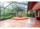 Beautiful screened patio with tile flooring and a wooden deck at 4215 Water Oaks Ln, Tampa, FL 33618