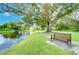 A park bench offers a scenic view of a pond and mature trees in this community at 4215 Water Oaks Ln, Tampa, FL 33618