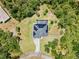 Bird's-eye view of the home surrounded by lush greenery, complemented by a screened in pool at 4323 Baynes Rd, North Port, FL 34288