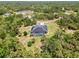 Aerial view of the house, featuring a pool, surrounded by an expanse of lush greenery at 4323 Baynes Rd, North Port, FL 34288