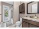 Well-lit bathroom with a granite-topped vanity, dark wood cabinets, and a shower-tub combo at 4323 Baynes Rd, North Port, FL 34288