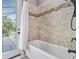 Bathtub with tiled backsplash, shower curtain and exterior view at 4323 Baynes Rd, North Port, FL 34288