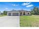 Inviting one-story home with a spacious three-car garage and green lawn at 4323 Baynes Rd, North Port, FL 34288