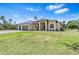 Well-manicured lawn leads up to the charming single-story home featuring a three-car garage at 4323 Baynes Rd, North Port, FL 34288