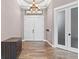 Bright foyer with tile flooring, white double doors, and a modern chandelier at 4323 Baynes Rd, North Port, FL 34288