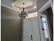 Elegant foyer boasts a decorative tray ceiling, statement chandelier and a window above the front door at 4323 Baynes Rd, North Port, FL 34288