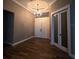 Charming foyer with wood-look tile flooring, decorative ceiling with chandelier, and stylish doors at 4323 Baynes Rd, North Port, FL 34288