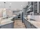 Bright kitchen with gray cabinets, granite countertops, stainless steel appliances, farmhouse sink and wood-look tile flooring at 4323 Baynes Rd, North Port, FL 34288