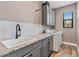 Well-equipped laundry room with gray cabinets, sink and modern appliances at 4323 Baynes Rd, North Port, FL 34288