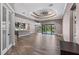 Bright, open living room with wood-look tile flooring and sliding glass doors to the pool at 4323 Baynes Rd, North Port, FL 34288