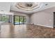 Spacious living room with wood-look tile flooring, fan, and sliding doors leading to the pool area at 4323 Baynes Rd, North Port, FL 34288