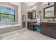 Beautiful bathroom with dual vanities, a built-in tub, a chandelier, and a separate make-up area at 4323 Baynes Rd, North Port, FL 34288