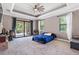 Large main bedroom featuring a tray ceiling, fan, and access to the patio at 4323 Baynes Rd, North Port, FL 34288