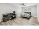 Bedroom with wood-look flooring, desk, chair, bed with gray plaid blanket, ceiling fan, and window with blinds at 4368 Marine Pkwy, New Port Richey, FL 34652
