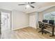 Bedroom featuring wood-look flooring, desk with monitors, door to bathroom, and a double door closet at 4368 Marine Pkwy, New Port Richey, FL 34652