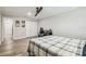 Bedroom with wood-look flooring, desk, chair, closet, ceiling fan, door to hallway, and a bed with gray plaid blanket at 4368 Marine Pkwy, New Port Richey, FL 34652