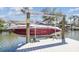 Image of a boat lift with a red and white boat; waterfront property with boating capabilities at 4368 Marine Pkwy, New Port Richey, FL 34652