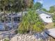 Bright white single story home, waterfront property with stone landscaping, and palm trees at 4368 Marine Pkwy, New Port Richey, FL 34652