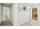 Hallway with wood-look flooring, light gray walls, decorative shelving and three framed pictures with a seaside theme at 4368 Marine Pkwy, New Port Richey, FL 34652