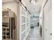 Hallway featuring wood-look floors and sliding barn doors accessing bedroom and bath areas at 4368 Marine Pkwy, New Port Richey, FL 34652