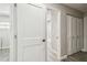 Hallway with wood-look flooring, closet, and an open doorway to the bathroom featuring a white door and black hardware at 4368 Marine Pkwy, New Port Richey, FL 34652