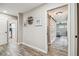 Bright hallway featuring decorative wall art, wood-look floors, and barn door access to the bedroom at 4368 Marine Pkwy, New Port Richey, FL 34652
