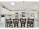 Kitchen with a large island featuring bar stools, white cabinets, and modern appliances at 4368 Marine Pkwy, New Port Richey, FL 34652