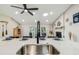 Kitchen island featuring a large sink, stainless steel faucet, and seating for four with views to the outdoor living area at 4368 Marine Pkwy, New Port Richey, FL 34652