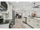 Open kitchen featuring stainless appliances, white cabinets, and wood-look flooring flowing into the living area at 4368 Marine Pkwy, New Port Richey, FL 34652