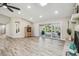Bright and open living room with hardwood floors, fireplace, and sliding glass doors to the outdoor living area at 4368 Marine Pkwy, New Port Richey, FL 34652