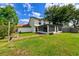 Well-manicured backyard with artificial turf, screen porch, and brick accents at 4520 Wescott Ln, Tampa, FL 33624