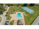 An aerial view of the community pool area, with multiple lounge chairs, tables, and a tennis court nearby at 4520 Wescott Ln, Tampa, FL 33624