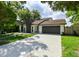 Well-maintained home featuring a long driveway, a front lawn with decorative rocks and lush greenery at 4520 Wescott Ln, Tampa, FL 33624