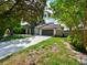 Well-maintained home featuring a long driveway, a front lawn with decorative rocks and lush greenery at 4520 Wescott Ln, Tampa, FL 33624