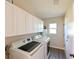Well-organized laundry room with modern appliances, ample cabinet space, and a convenient utility sink at 4520 Wescott Ln, Tampa, FL 33624