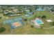 Aerial shot showcasing community recreational area with tennis courts, basketball court, pool, and green space near a lake at 4520 Wescott Ln, Tampa, FL 33624