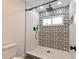 Stylish shower featuring black-and-white patterned tile work, a rainfall showerhead, and modern fixtures at 4520 Wescott Ln, Tampa, FL 33624