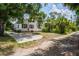 Side view of a charming home with green lawn, driveway and mature trees at 4568 18Th S Ave, St Petersburg, FL 33711