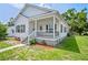 Charming home featuring a porch, white siding, black shutters, and landscaped yard at 4568 18Th S Ave, St Petersburg, FL 33711