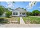 Charming home with white siding, dark shutters, a well-manicured lawn and mature trees at 4568 18Th S Ave, St Petersburg, FL 33711