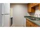 Kitchen featuring wooden cabinets, a stainless steel sink, white appliances, and neutral tiled floor at 4724 Michael Ct # 122, Tampa, FL 33614