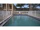 Community pool with white fence surround and lounge chairs for residents at 4724 Michael Ct # 122, Tampa, FL 33614
