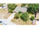 An aerial view of the property highlighting the home, mature trees, extended drive, and screened-in lanai at 5298 Florentine Ct, Spring Hill, FL 34608